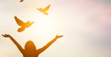 woman opening her arms up in prayer