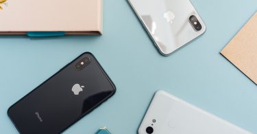 photo of four iphones on blue surface