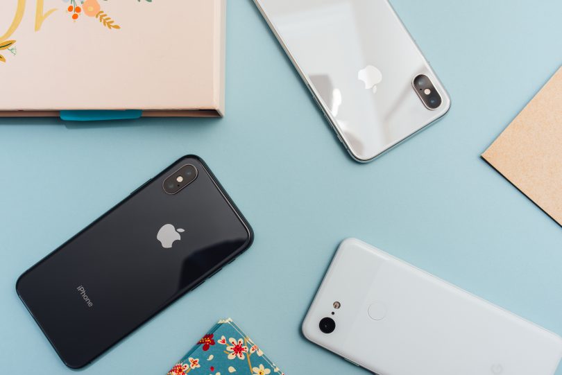 photo of four iphones on blue surface